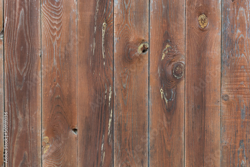 The background is made of brown boards painted with stain. The texture of a wooden table, fence.