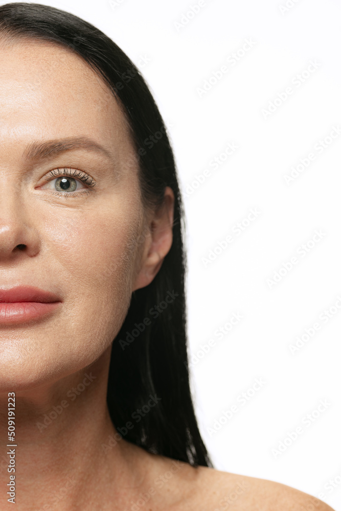 Cropped portrait of middle age, 44 years old beautiful woman with long black hair on white background. Beauty, spa, age-related changes, face lifting and skin care concept Cropped portrait of middle age, 44 years old beautiful woman with long black hair on white background. Beauty, spa, age-related changes, face lifting and skin care concept