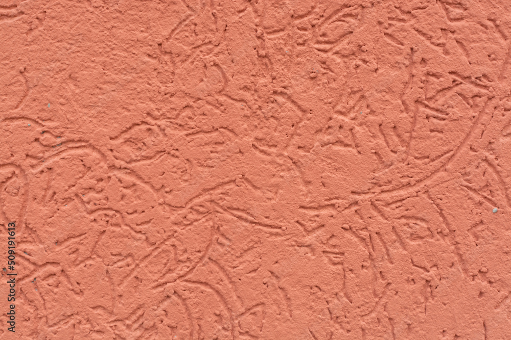 Coral background (texture) with a pattern. Concrete painted wall.