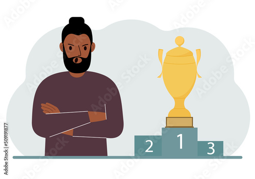 A man next to the pedestal on which the cup for victory and first place.