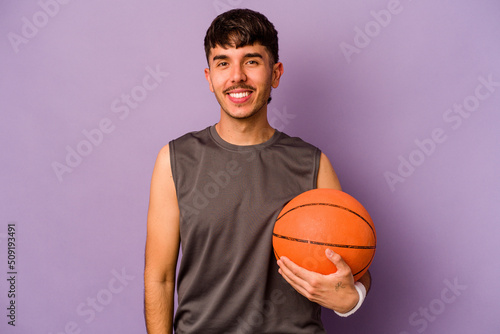Young hispanic basketball player man isolated on purple background happy, smiling and cheerful.