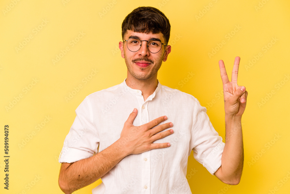 Young caucasian man isolated on yellow background taking an oath, putting hand on chest. Young caucasian man isolated on yellow background taking an oath, putting hand on chest.