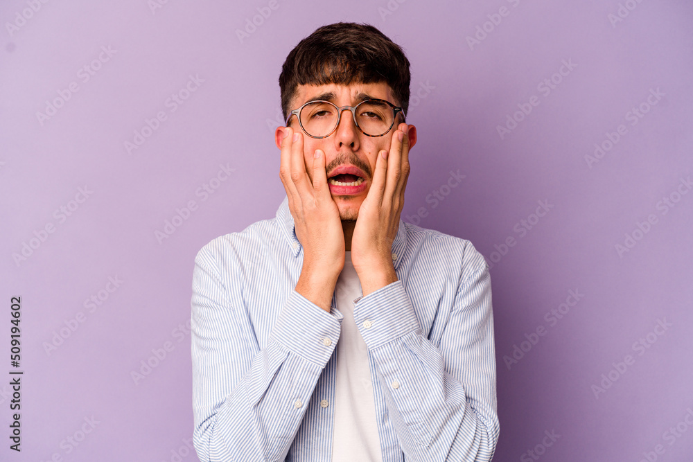 Young caucasian man isolated on purple background crying, unhappy with something, agony and confusion concept. Young caucasian man isolated on purple background crying, unhappy with something, agony and confusion concept.