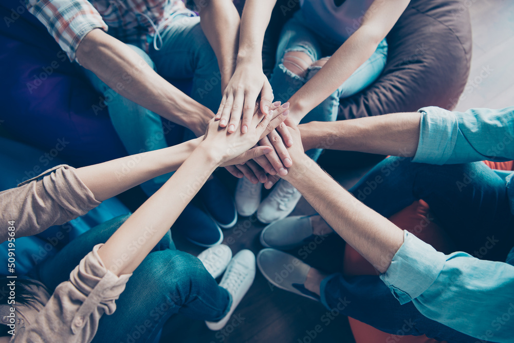 Cropped photo of friendly cheerful workers shacking arms together teambuilding lesson indoors workplace workshop Cropped photo of friendly cheerful workers shacking arms together teambuilding lesson indoors workplace workshop