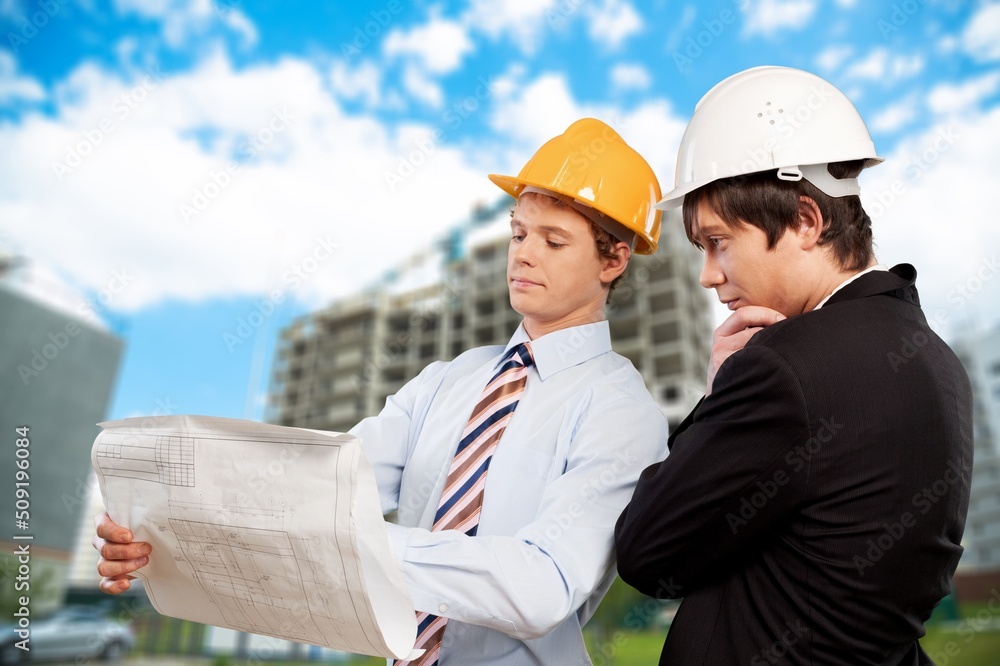 Engineer or architect with building plan at construction site, business, building, industry, people concept. Engineer or architect with building plan at construction site, business, building, industry, people concept.