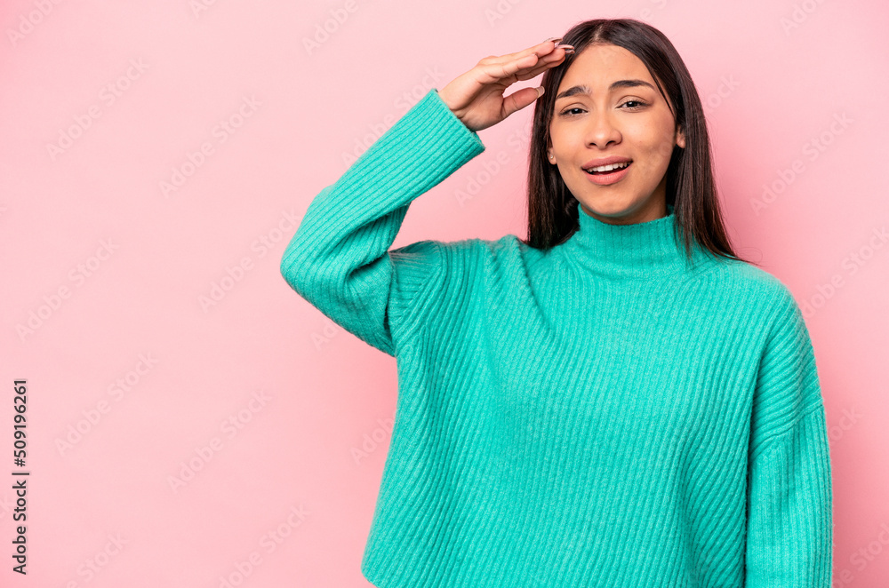 Young hispanic woman isolated on pink background shouts loud, keeps eyes opened and hands tense. Young hispanic woman isolated on pink background shouts loud, keeps eyes opened and hands tense.