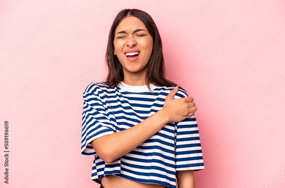 Young hispanic woman isolated on pink background having a shoulder pain. Young hispanic woman isolated on pink background having a shoulder pain.
