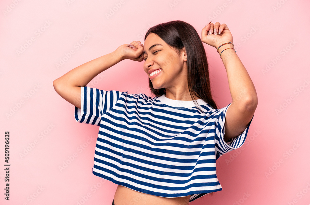 Young hispanic woman isolated on pink background celebrating a special day, jumps and raise arms with energy. Young hispanic woman isolated on pink background celebrating a special day, jumps and raise arms with energy.