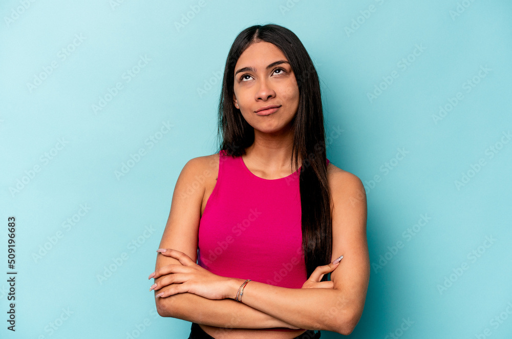 Young hispanic woman isolated on blue background tired of a repetitive task. Young hispanic woman isolated on blue background tired of a repetitive task.