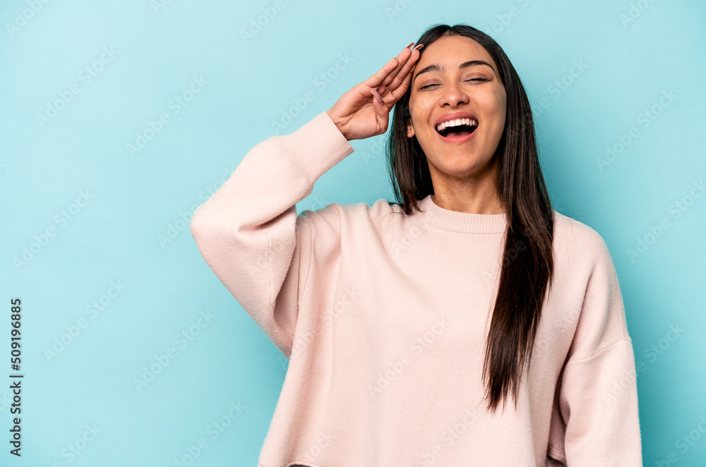 Young hispanic woman isolated on blue background shouts loud, keeps eyes opened and hands tense. Young hispanic woman isolated on blue background shouts loud, keeps eyes opened and hands tense.