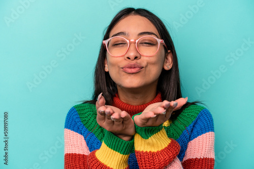 Young caucasian woman wearing a pink glasses isolated on blue background