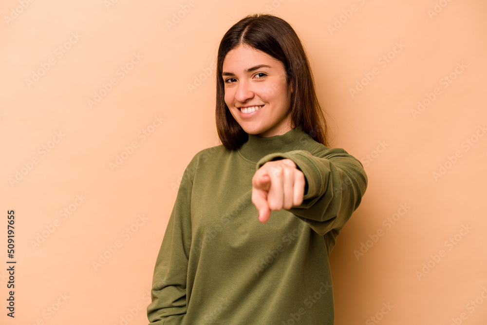 Young hispanic woman isolated on beige background cheerful smiles pointing to front. Young hispanic woman isolated on beige background cheerful smiles pointing to front.