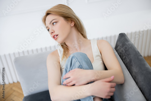 Young blonde woman resting on couch at home. Free Download Young blonde woman resting on couch at home. - GFXLoad