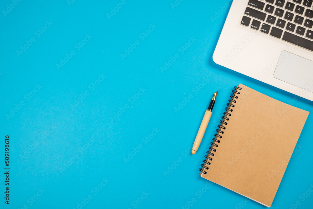 top view of laptop notepad and pen on blue top view of laptop notepad and pen on blue
