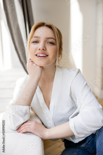 Portrait of cheerful blonde woman in blouse looking at camera at home. Free Download Portrait of cheerful blonde woman in blouse looking at camera at home. - GFXLoad