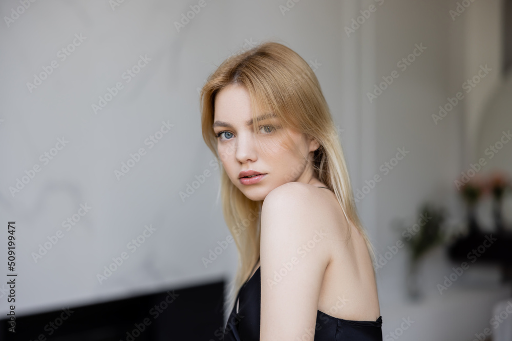 Woman looking at camera in living room. Woman looking at camera in living room.