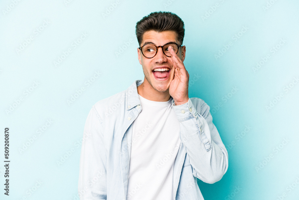 Young caucasian man isolated on blue background shouting excited to front. Young caucasian man isolated on blue background shouting excited to front.
