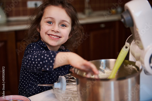 Photography Cute European little assistant smiles cheerfully and makes funny faces while lic