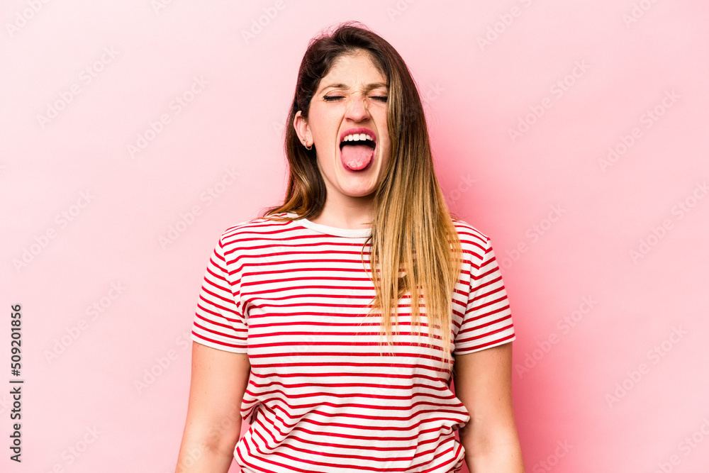 Young caucasian woman isolated on pink background funny and friendly sticking out tongue. Young caucasian woman isolated on pink background funny and friendly sticking out tongue.