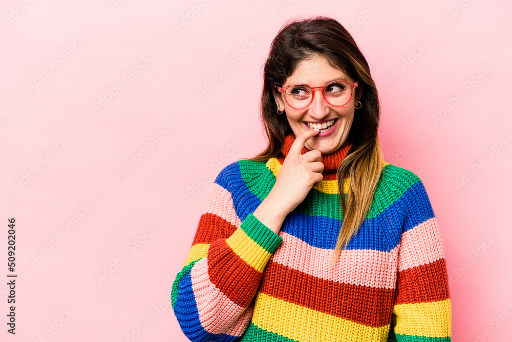 Young caucasian woman isolated on pink background relaxed thinking about something looking at a copy space. Young caucasian woman isolated on pink background relaxed thinking about something looking at a copy space.