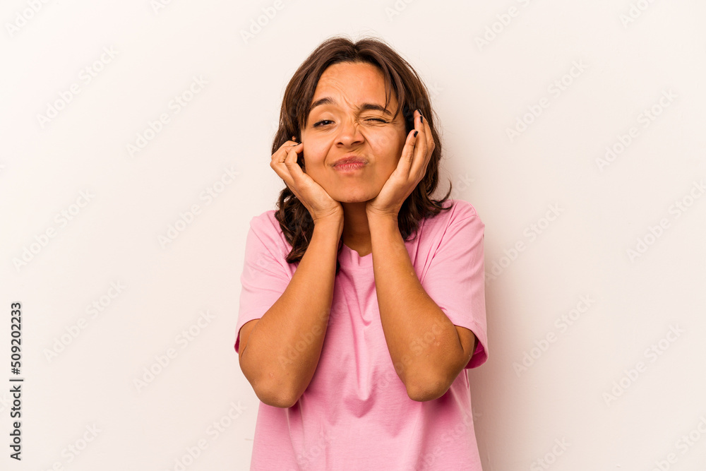 Young hispanic woman isolated on white background covering ears with hands. Young hispanic woman isolated on white background covering ears with hands.
