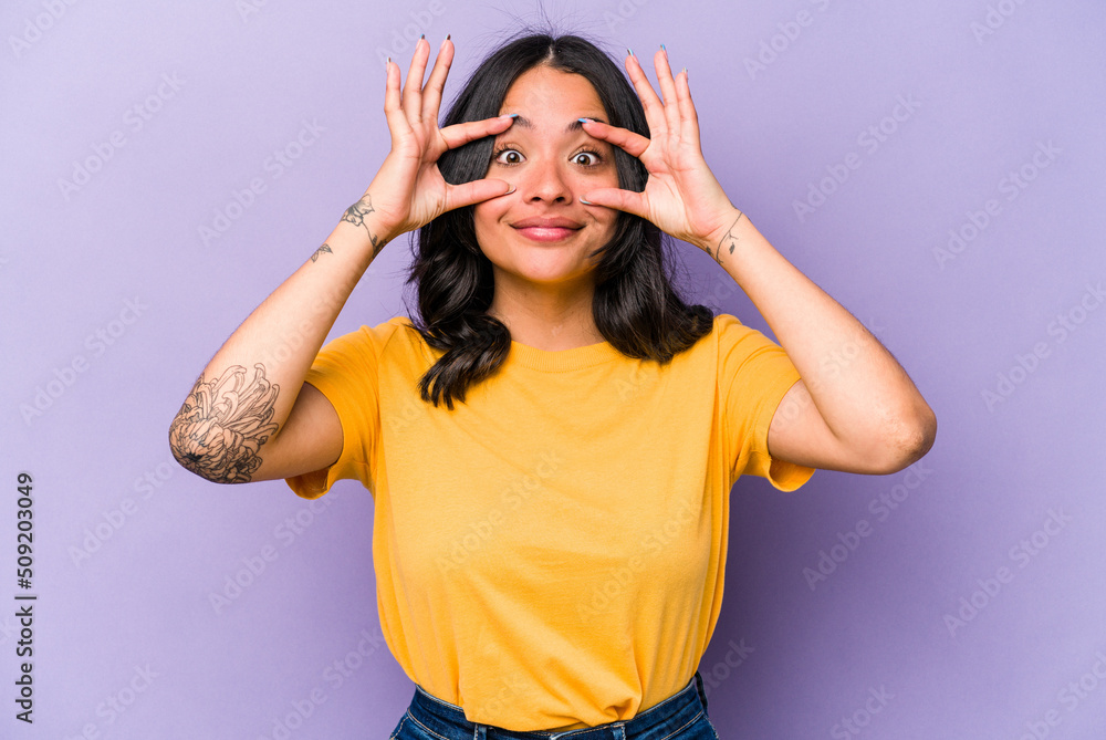 Young hispanic woman isolated on purple background keeping eyes opened to find a success opportunity. Young hispanic woman isolated on purple background keeping eyes opened to find a success opportunity.