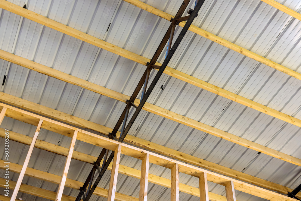 The roof of the new metal frame warehouse is covered with roofing panels in construction site