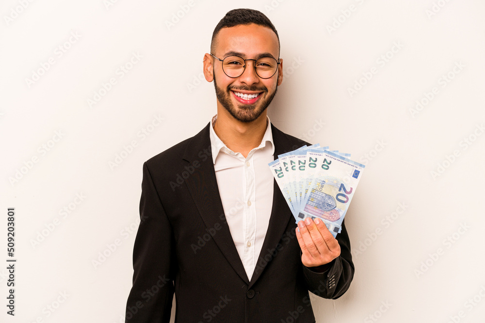 Young business hispanic man holding banknotes isolated on white background laughing and having fun. Young business hispanic man holding banknotes isolated on white background laughing and having fun.