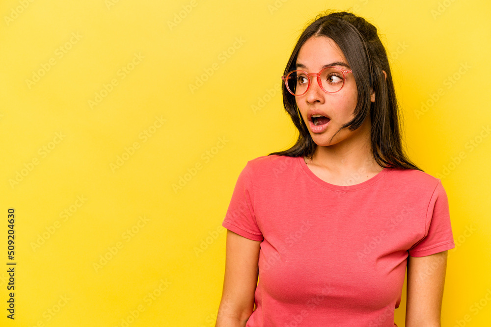 Fototapeta premium Young hispanic woman isolated on yellow background being shocked because of something she has seen.