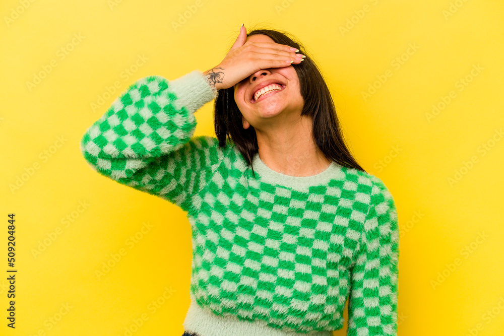 Young hispanic woman isolated on yellow background laughs joyfully keeping hands on head. Happiness concept. Young hispanic woman isolated on yellow background laughs joyfully keeping hands on head. Happiness concept.