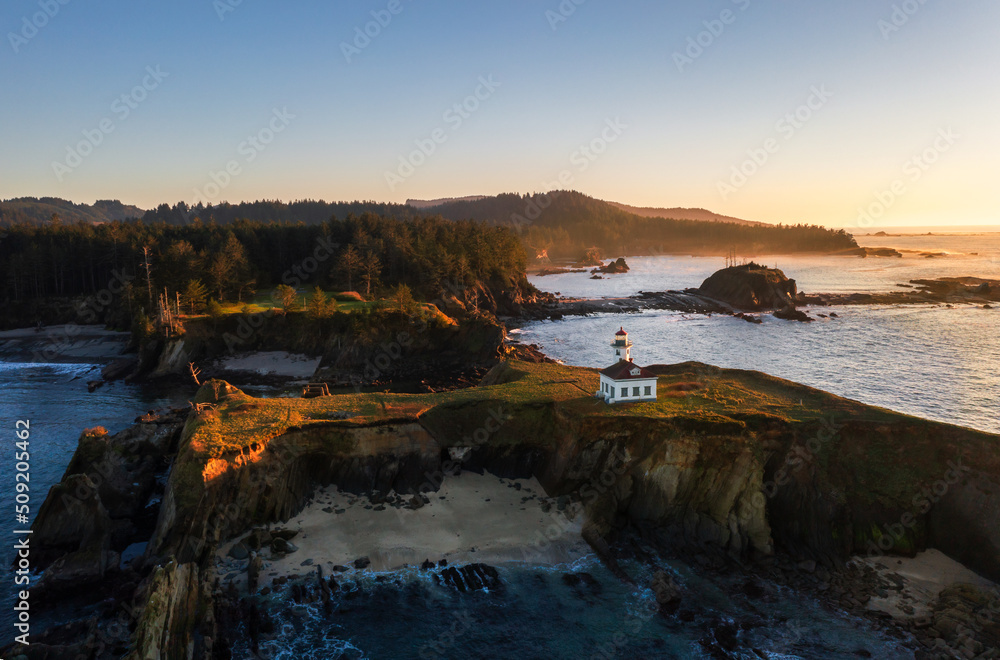 Cape Arago Lighthouse at the Oregon Coast at sunset. Also seen are Shore Acres and Sunset Bay State Park. 