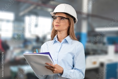 Woman engineer working control machine in factory.