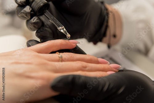 nail salon. workplace of a manicurist. manicurist paints nails to a client.