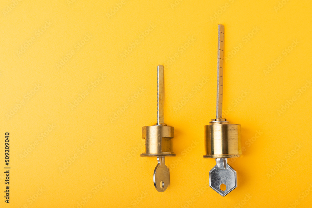 New door lock on a yellow background. Patent and keys from the front door. Contact tumbler of the internal mechanism of the cylinder lock and a set of keys. Real estate concept New door lock on a yellow background. Patent and keys from the front door. Contact tumbler of the internal mechanism of the cylinder lock and a set of keys. Real estate concept