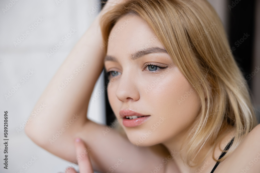 Portrait of blonde woman looking away at home. Portrait of blonde woman looking away at home.