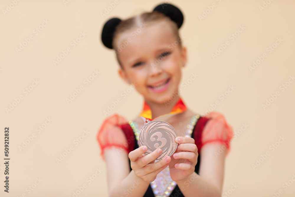 gymnastics girl with make up and hair dressing posing on beige background