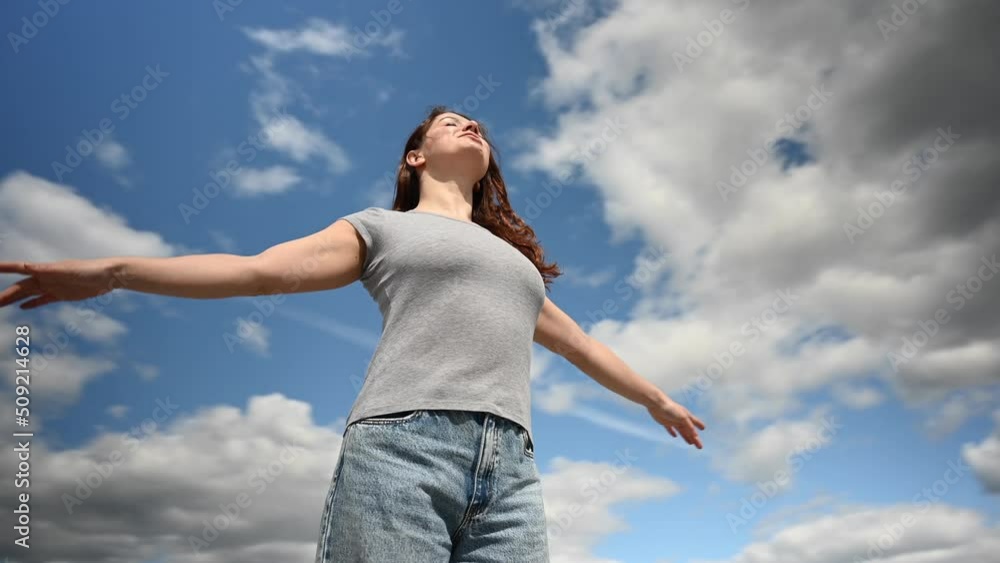 Caucasian woman spread her arms like wings against a cloudy sky. Video 360 degrees. Caucasian woman spread her arms like wings against a cloudy sky. Video 360 degrees.