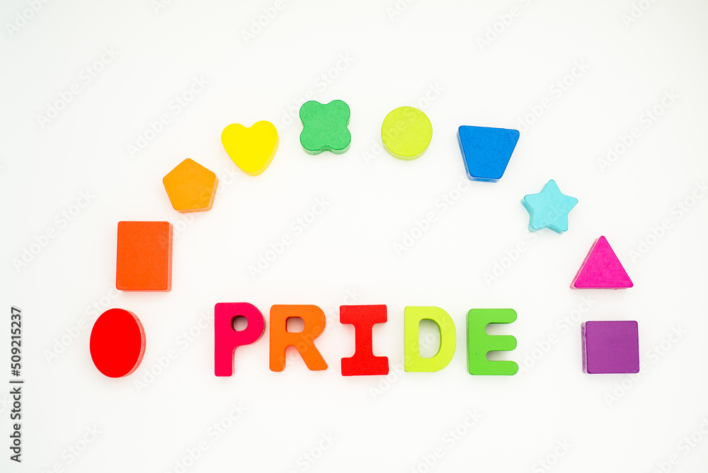 Word pride with rainbow in colored block lettering with colored rainbow shapes in background on white lay flat