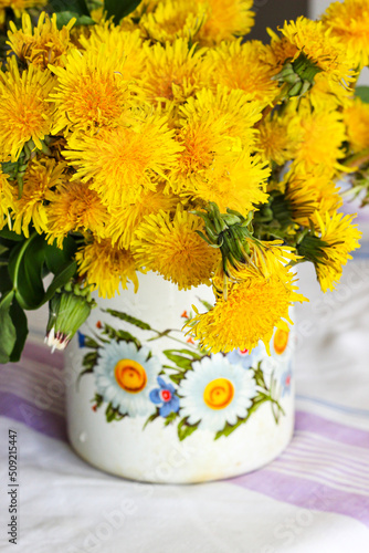 Yellow dandelions in a rustic vase
