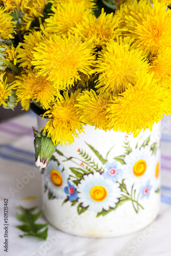 Yellow dandelions in a rustic vase