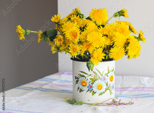Yellow dandelions in a rustic vase