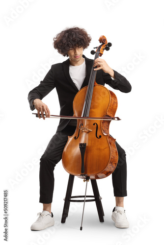 Young male artist sitting on a chair and playing a contrabass