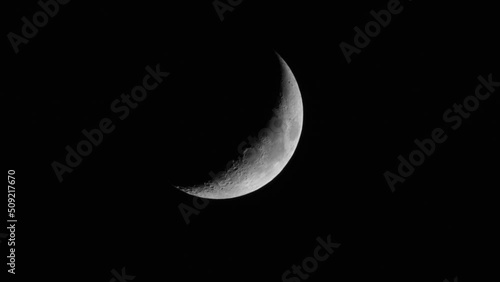 Quarter crescent moon, on a black background of the night. Lunar surface with craters. photo