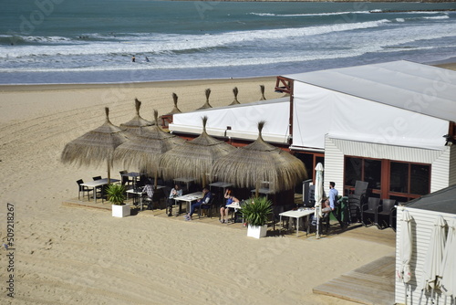 Cadiz, Spain - 06 november 2019: Cafe with umbrellas on the city beach