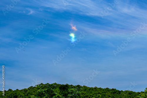 A small Cloudbow forms on this bright Spring Afternoon. Sun shining thru clouds turns them into a rainbow.