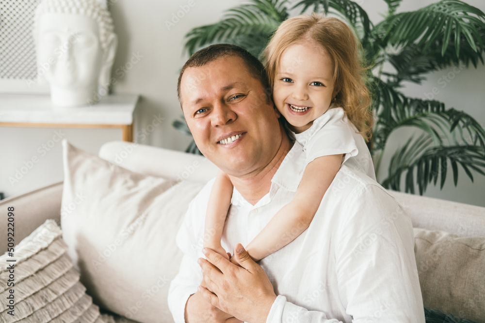 A little girl 4 years old gently hugs her dad. A little girl 4 years old gently hugs her dad.