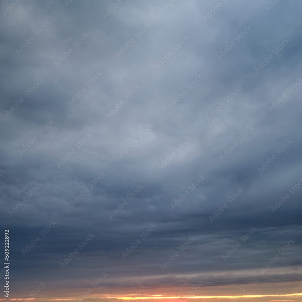 Dark rain clouds in the evening sky. Dramatic sky with an coming cloudy cyclone of bad weather