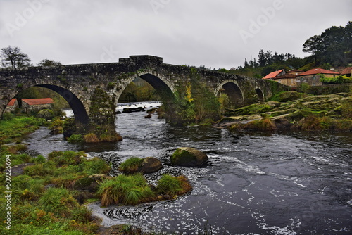 Old stone bridge with arches across the river. The Way of St. James, Northern Route, Spain.