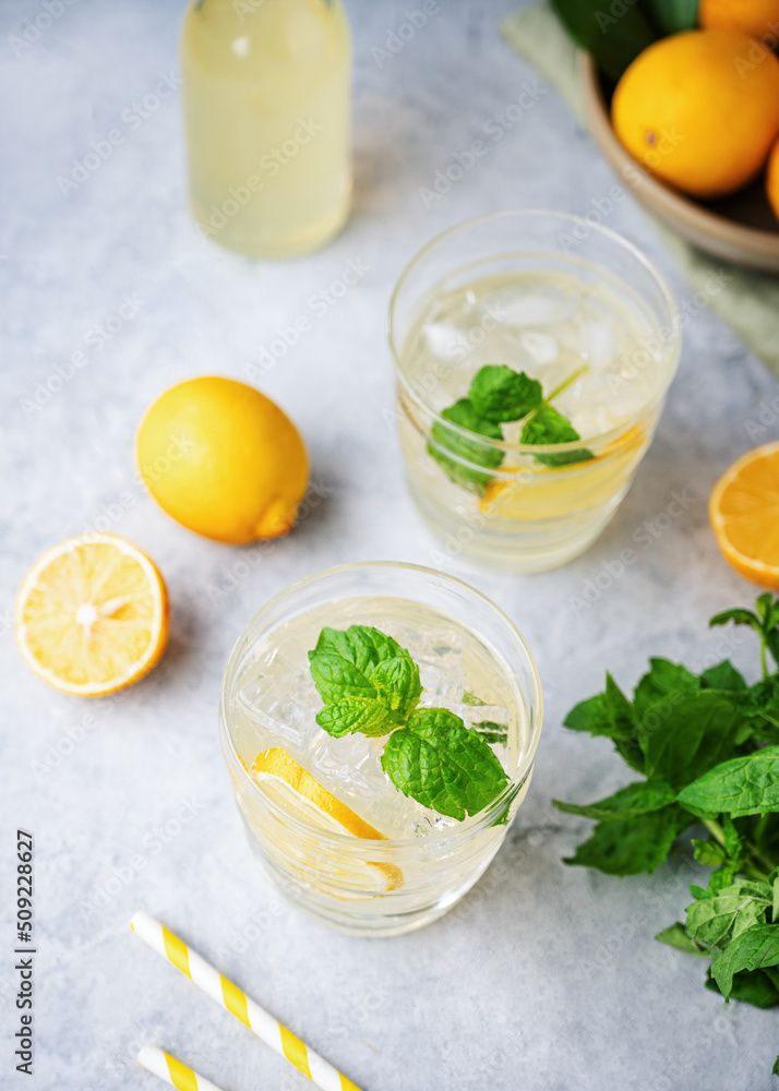 Lemonade soda drink with fresh lemons. Refreshing cocktail with lemon, mint and ice on blue background. Summer cold drinks concept. Top view Lemonade soda drink with fresh lemons. Refreshing cocktail with lemon, mint and ice on blue background. Summer cold drinks concept. Top view