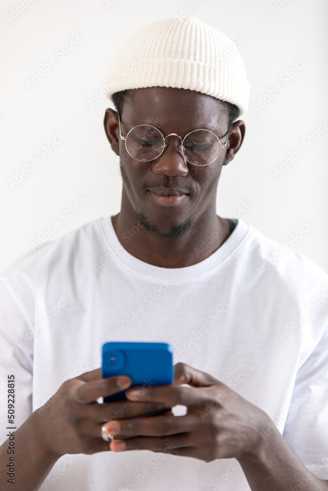 African american man in eyeglasses and white hat using smartphone. African american man in eyeglasses and white hat using smartphone.